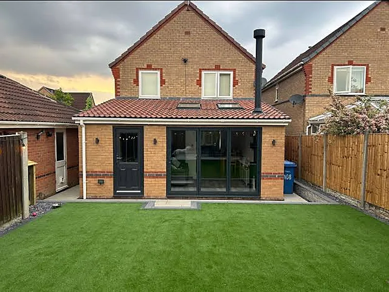 Black bi-folding doors opening onto a garden at a brick house in Yorkshire